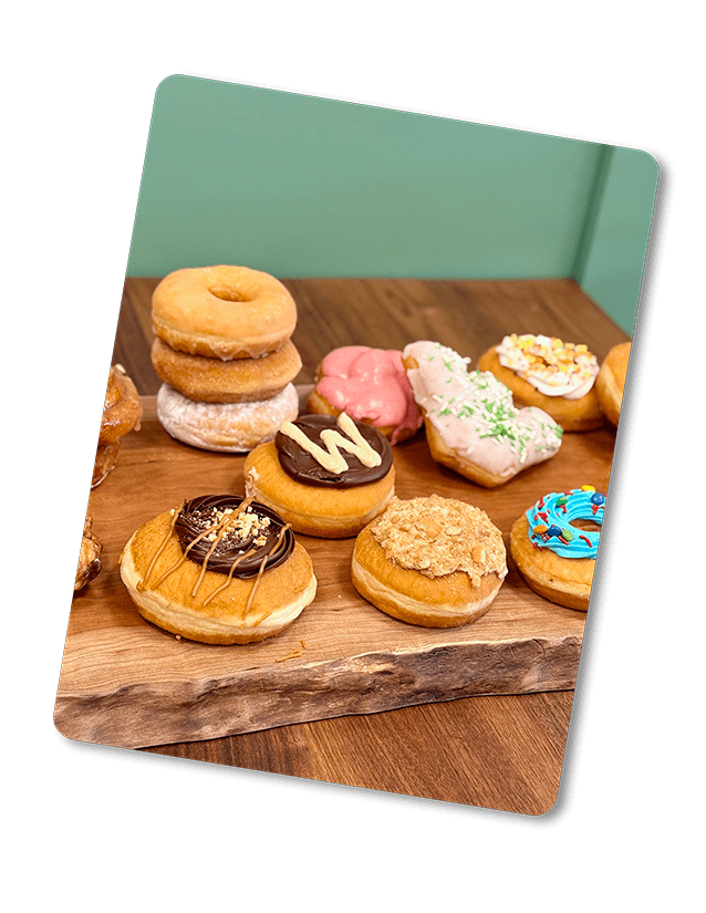 An assortment of donuts on a wooden tray